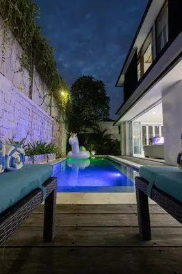 a swimming pool in front of a house at night at Lacasa2 Villa Legian With Butler in Legian