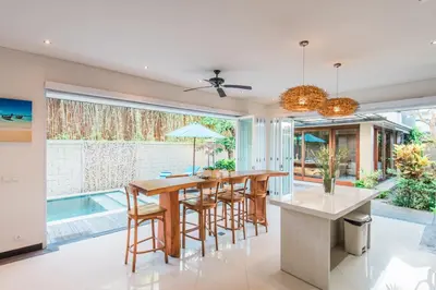 a kitchen with a table and chairs and a large window at Lacasa3 Villa Legian With Butler in Legian