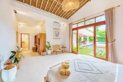 a bedroom with a large bed and a large window at Villa Indigo - 5-BDR with huge pool and garden in Seminyak