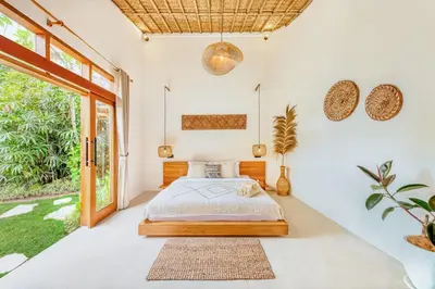 a bedroom with a bed and a large window at Villa Indigo - 5-BDR with huge pool and garden in Seminyak