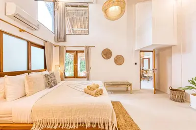 a bedroom with a large bed with a teddy bear on it at Villa Indigo - 5-BDR with huge pool and garden in Seminyak