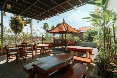 a patio with tables and chairs and a gazebo at Umah Kita in Seminyak