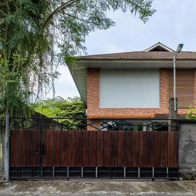 a wooden fence in front of a house at Cove Matahari Guesthouse Sunset in Legian