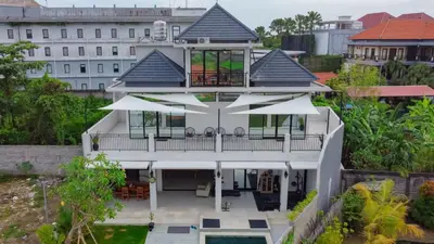 an aerial view of a white house with large windows at Berawa Homestay in Canggu