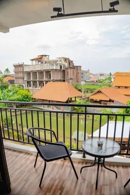 a balcony with a table and chairs and a view at Berawa Homestay in Canggu