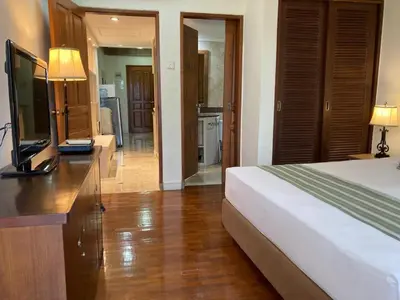 a bedroom with a bed and a dresser with a television at Coastal Suite at Jayakarta Residence in Seminyak