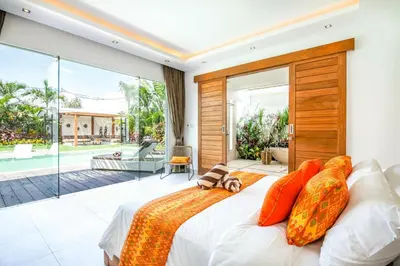 a bedroom with a large bed with orange pillows at Canggu 400m to Beach Escape 4br Designer villa in Canggu