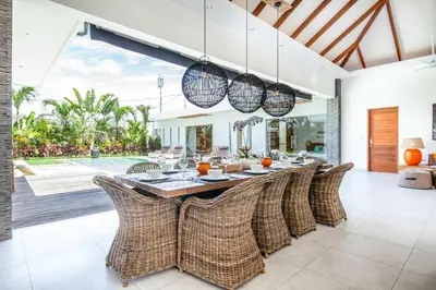 a dining room with a table and rattan chairs at Canggu 400m to Beach Escape 4br Designer villa in Canggu
