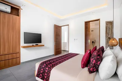 a bedroom with a bed with a television on the wall at Villa GoodFellas by BaliSuperHost in Seminyak