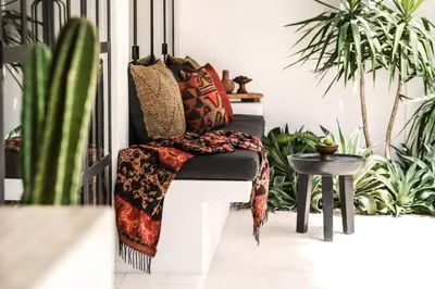 a porch with plants and a bench with a blanket on it at Villa Obao in Seminyak