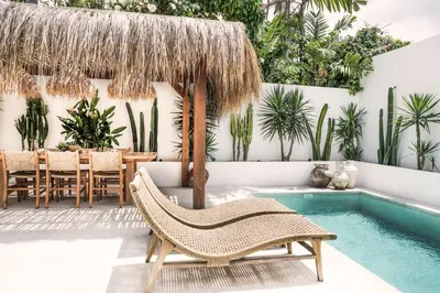 a patio with a chair and a swimming pool at Villa Obao in Seminyak