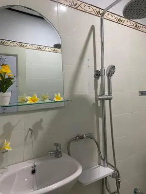 a bathroom with a sink and a shower with a mirror at Guest House Pondok Puspa Ayu in Kuta