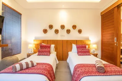 two beds in a hotel room with red pillows at Incredible 4BR Villa 5 mins walk to the beach in Canggu