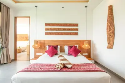 a bedroom with a large white bed with red pillows at Incredible 4BR Villa 5 mins walk to the beach in Canggu