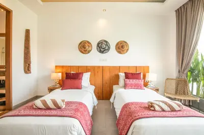 a bedroom with two beds with red pillows on them at Incredible 4BR Villa 5 mins walk to the beach in Canggu