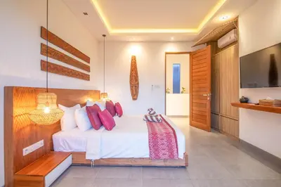 a bedroom with a white bed with red pillows at Incredible 4BR Villa 5 mins walk to the beach in Canggu