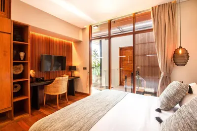 a bedroom with a bed and a desk and a television at Elegant 6BR Villa, Canggu, 400m to Finns Beach in Canggu