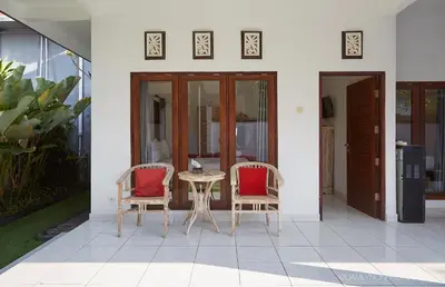 a patio with two chairs and a table at Villa Ari in Seminyak