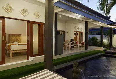 a villa with a swimming pool and a bedroom at Villa Kaya in Seminyak