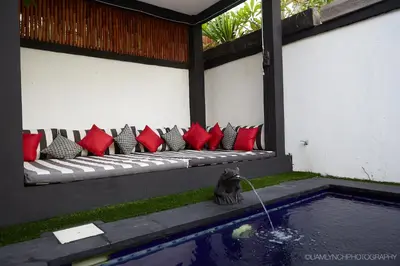 a bench with red and black pillows next to a pool at Massive 6-bedroom Villa with 2 Pools in Seminyak