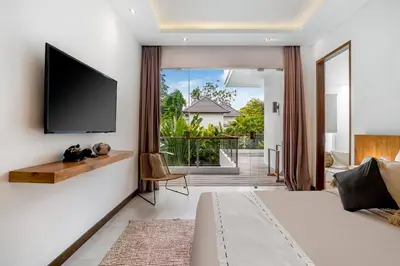 a bedroom with a flat screen tv on a wall at Villa Ara by BaliSuperHost in Seminyak