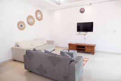 a living room with two couches and a flat screen tv at Villa Bristol in Seminyak