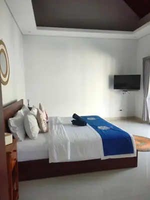 a bedroom with a bed and a flat screen tv at Villa Bristol in Seminyak