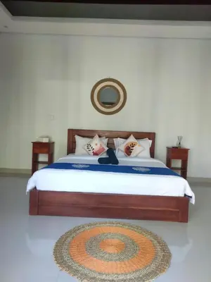 a bedroom with a large bed with a rug on the floor at Villa Bristol in Seminyak