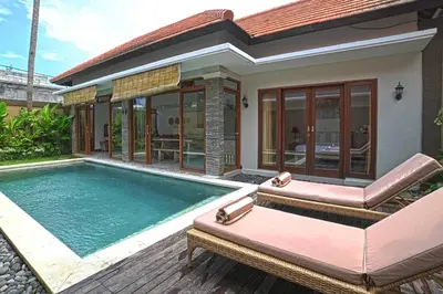 a villa with a swimming pool and a house at Villa Searenity Seminyak in Seminyak