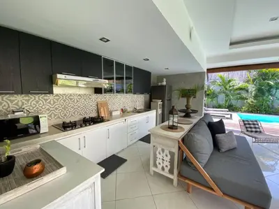 a kitchen with a couch in the middle of a room at Villa Dharsan in Seminyak