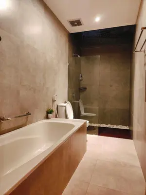 a bathroom with a tub and a toilet and a sink at Rabasta Enjoy Kuta in Denpasar