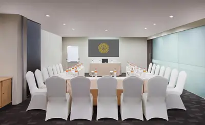 a conference room with a long table and white chairs at Brits Hotel Legian in Seminyak