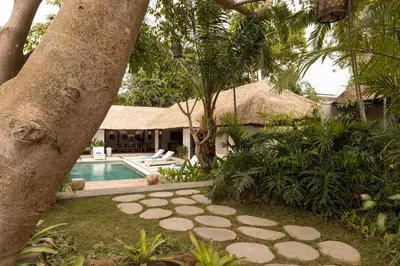 a backyard with a swimming pool and a tree at Large 6-Bedroom Private Villa with Pool for Groups & Families - Umalas in Kerobokan