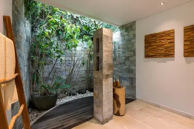 a bathroom with a stone wall with a water fountain at Villa Reina by SooBali - Spacious & Modern near Canggu with Butler-Cook, Private Pool and Tropical Gardens in Kerobokan