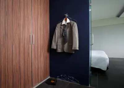a coat hanging on a wall next to a closet at Berry Biz Hotel Sunset Road in Seminyak
