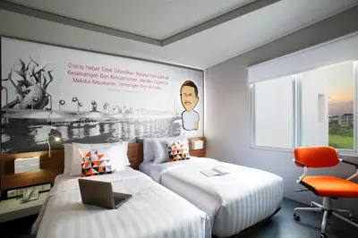 a hotel room with two beds and a laptop on top at Berry Biz Hotel Sunset Road in Seminyak