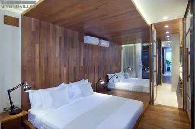 a bedroom with two white beds and a wooden wall at 8BR Villa Jumis - Minggu Villas Seminyak in Seminyak
