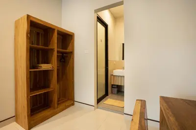 a room with wooden shelves and a door to a bathroom at K Hostel Seminyak in Seminyak