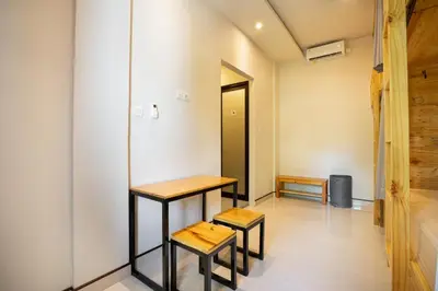 a room with two tables and two stools at K Hostel Seminyak in Seminyak
