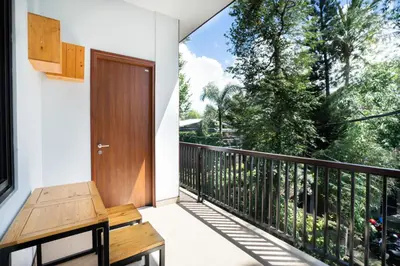 a balcony with a wooden door and a bench at K Hostel Seminyak in Seminyak