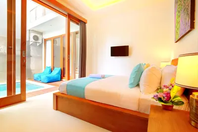 a bedroom with a bed and a pool at Villa Noam By Bali Asia Villa in Jimbaran