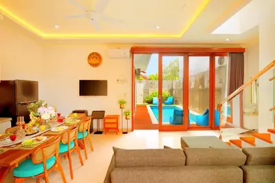 a living room with a long table and a couch at Villa Noam By Bali Asia Villa in Jimbaran