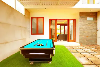 a pool table on a lawn in front of a house at Villa Noam By Bali Asia Villa in Jimbaran