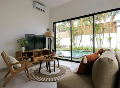 a living room with a couch and a tv and a table at VILLA NIKOLE in Seminyak
