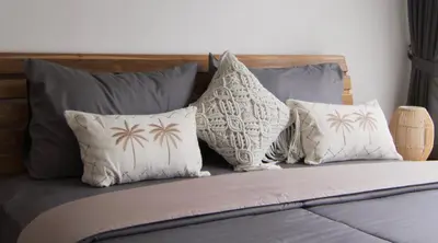 a bed with four pillows on top of it at VILLA NIKOLE in Seminyak