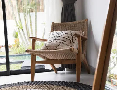 a wicker chair in a room with a window at VILLA NIKOLE in Seminyak