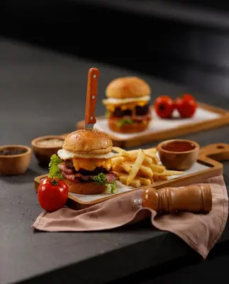 a plate of food with a hamburger and french fries at The Mahata in Legian