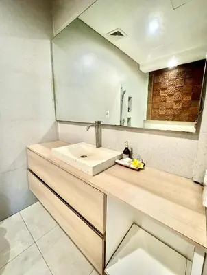 a bathroom with a sink and a mirror at The Hita Apartement in Seminyak
