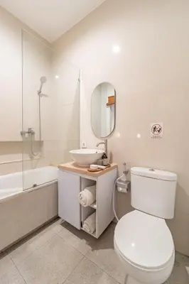 a bathroom with a toilet and a sink and a tub at The Hita Apartement in Seminyak