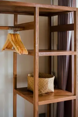 a wooden book shelf with a basket on it at Donguri House Bali in Jimbaran